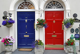 Vibrant Blue And Red Front Doors With Flower Baskets In Ireland
