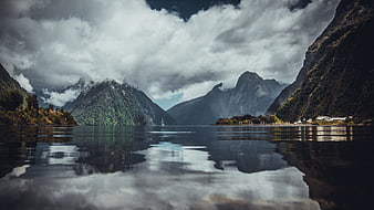 Dramatic mountain landscape with lake reflection and clouds