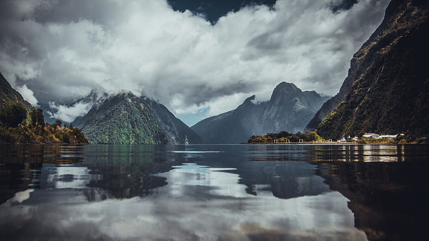 Dramatic mountain landscape with lake reflection and clouds