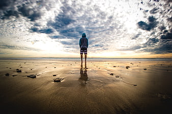 Lone Man Standing on Beach at Sunset