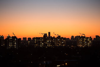 City skyline silhouette at sunset with smokestacks