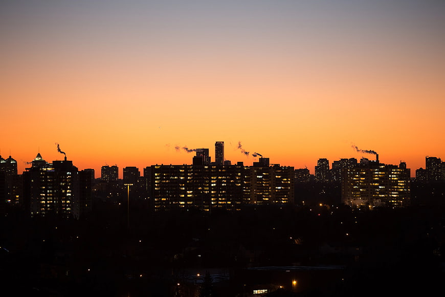 City skyline silhouette at sunset with smokestacks