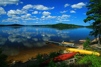 Serene Lake Landscape with Canoes and Cloud Reflections
