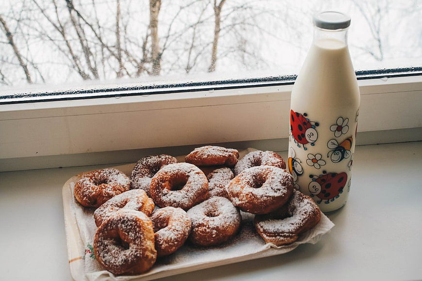 Fresh Powdered Donuts and Milk Bottle on Windowsill