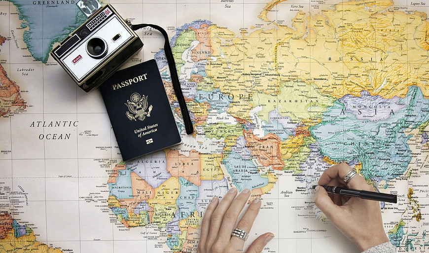 Travel planning with vintage camera, passport, and world map