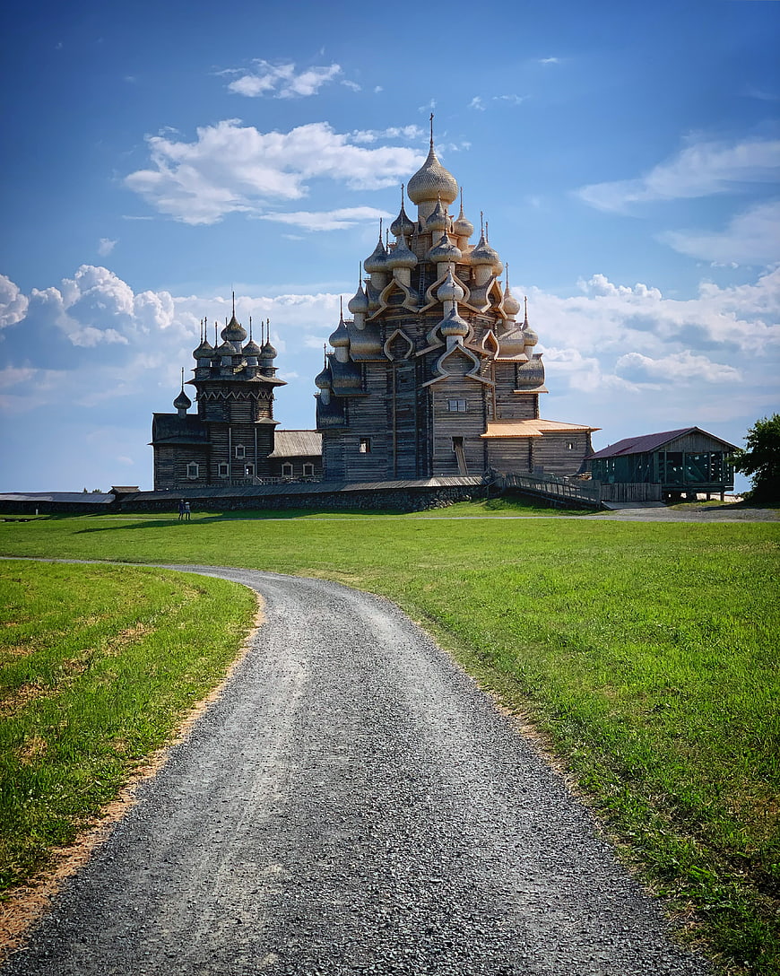 Wooden Russian Orthodox Church with Onion Domes on Grassy Hill