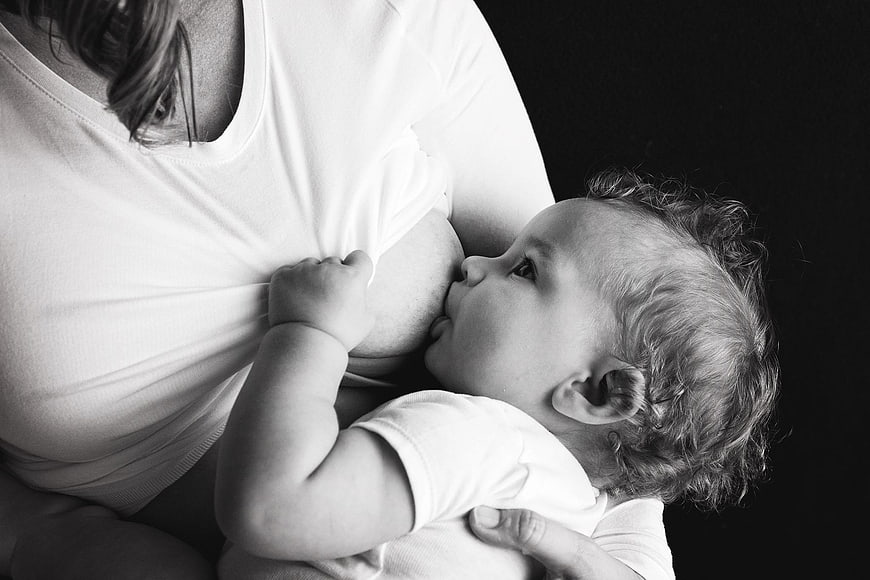 Black and white photo of mother breastfeeding baby
