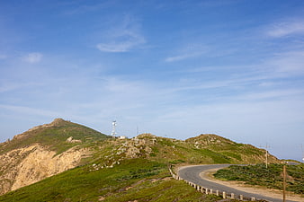 Winding Mountain Road with Cell Tower and Blue Sky