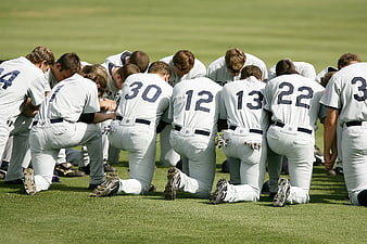 Baseball Team Kneeling in Prayer on Grass Field