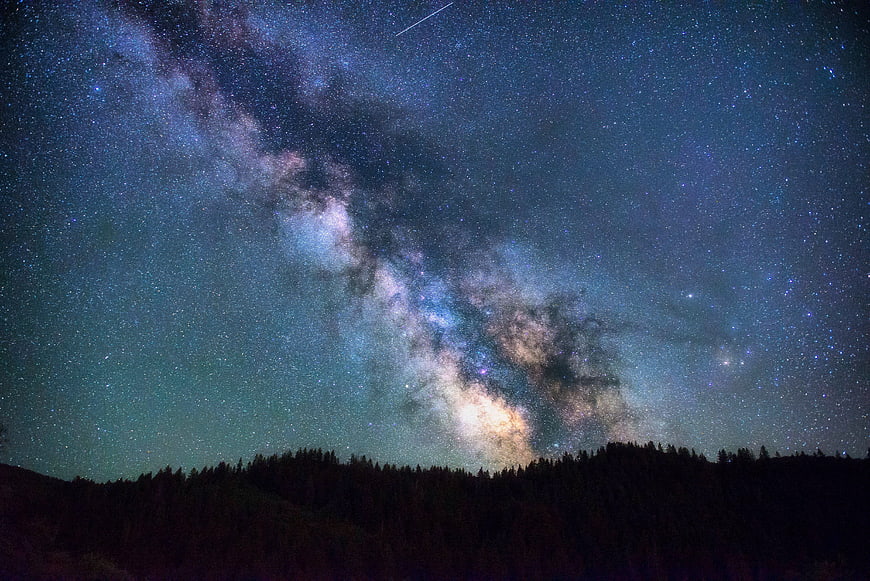 Milky Way Galaxy Over Silhouetted Forest at Night