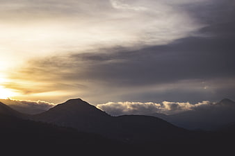 Dramatic Mountain Silhouette at Sunset with Clouds