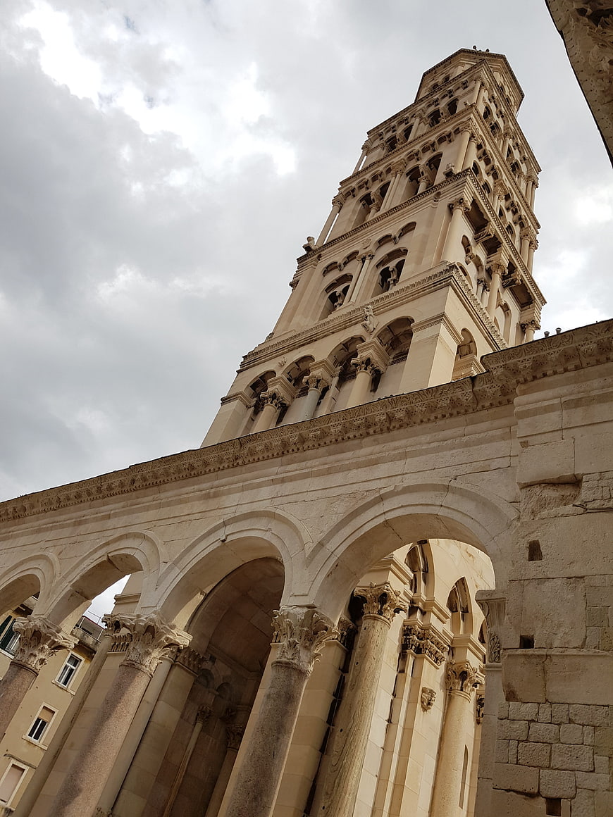 Low angle view of Pula Cathedral tower and Romanesque arcade