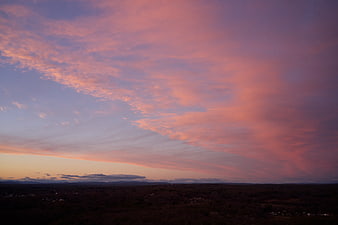 Dramatic Pink and Purple Sunset Sky Over Dark Forest Landscape
