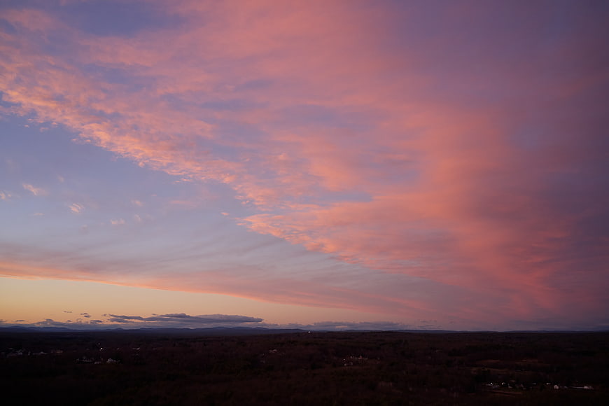 Dramatic Pink and Purple Sunset Sky Over Dark Forest Landscape