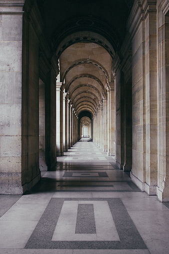Perspective of a grand stone colonnade hallway with arches