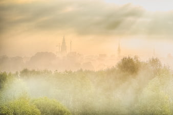 Foggy city skyline with sun breaking through clouds