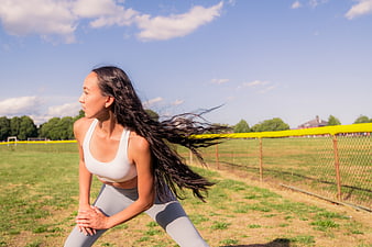 Athletic woman stretching outdoors on a sunny day
