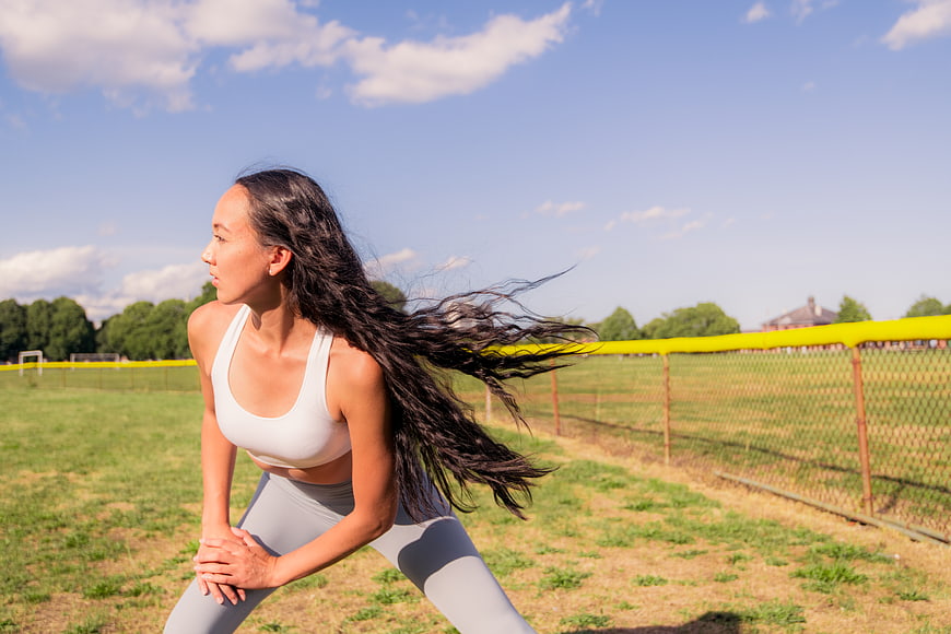 Athletic woman stretching outdoors on a sunny day