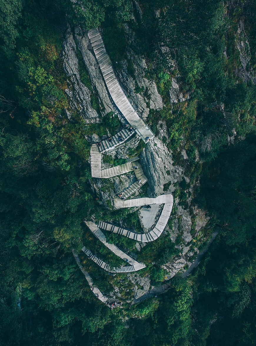 Aerial view of winding stone stairs on a steep mountain cliff