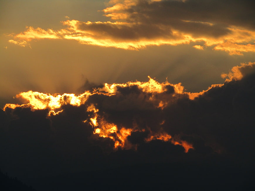 Dramatic golden sunset clouds with sun rays