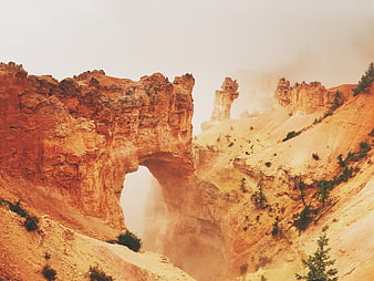 Misty Orange Rock Arch in Canyon Landscape