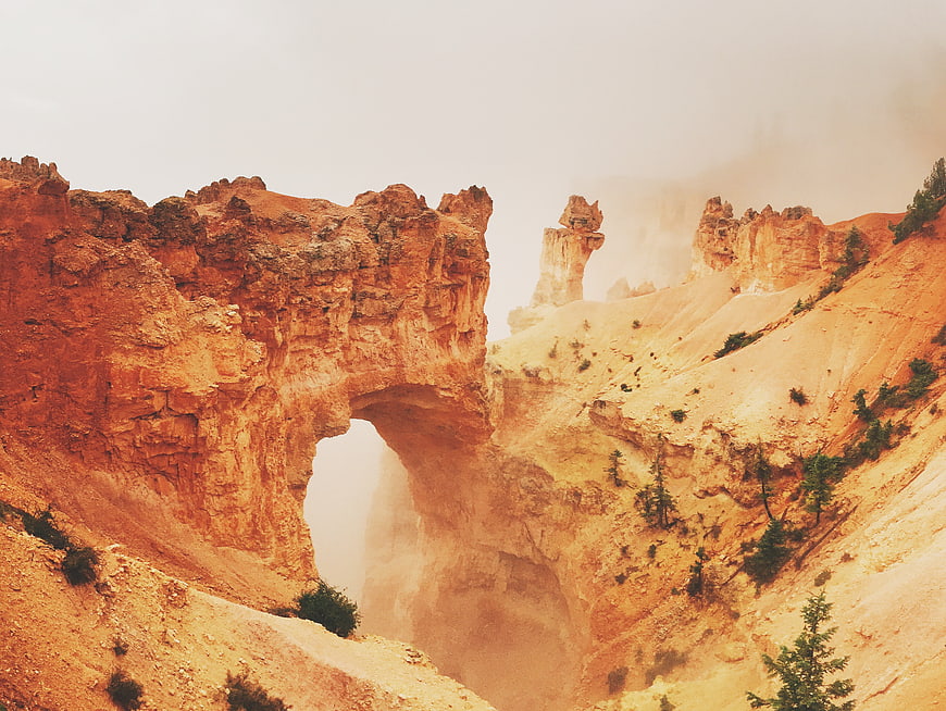 Misty Orange Rock Arch in Canyon Landscape