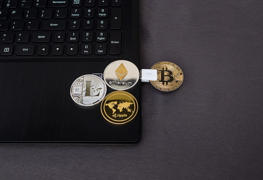 Cryptocurrency coins on laptop with USB drive