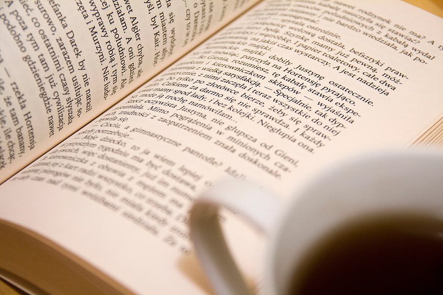 Open Book with Polish Text and Coffee Cup