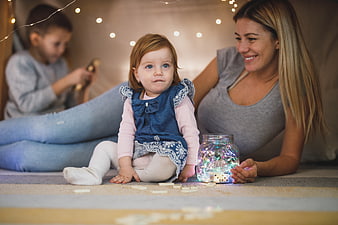 Mother and Toddler Playing with Fairy Lights Indoors