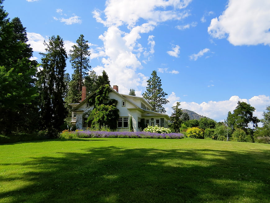 White Country House with Green Lawn and Blue Sky