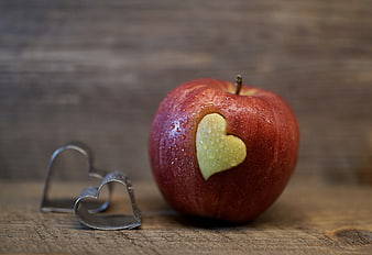 Red Apple with Heart Shape Cutout on Wooden Background