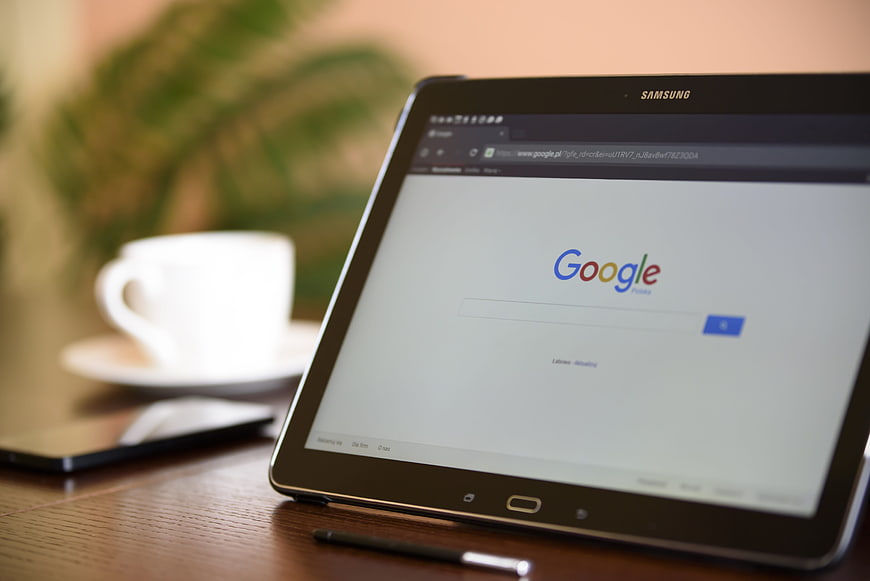 Samsung tablet displaying Google search page on wooden desk