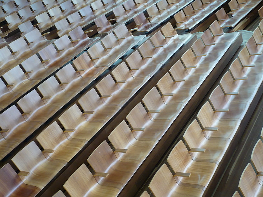 Rows of empty wooden theater seats in modern auditorium