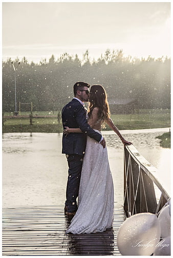 Romantic Wedding Couple Kissing in Rain on Wooden Pier