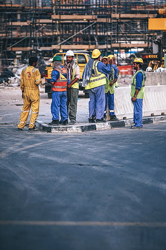 Construction workers in safety gear discussing on site