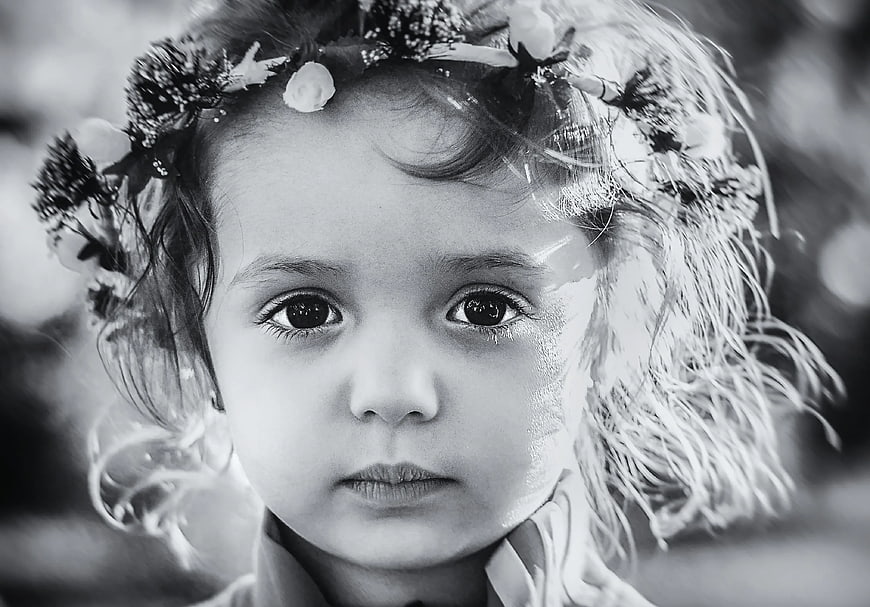 Black and white portrait of a child with a floral crown
