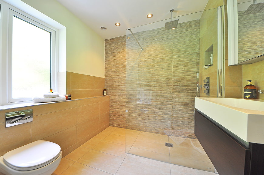 Modern beige bathroom with glass shower and floating vanity