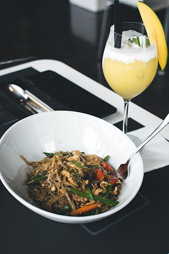 Thai Pad Thai noodles and mango smoothie in a restaurant