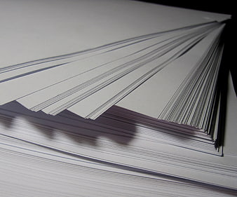 Stack of white paper sheets fanned out on a dark background