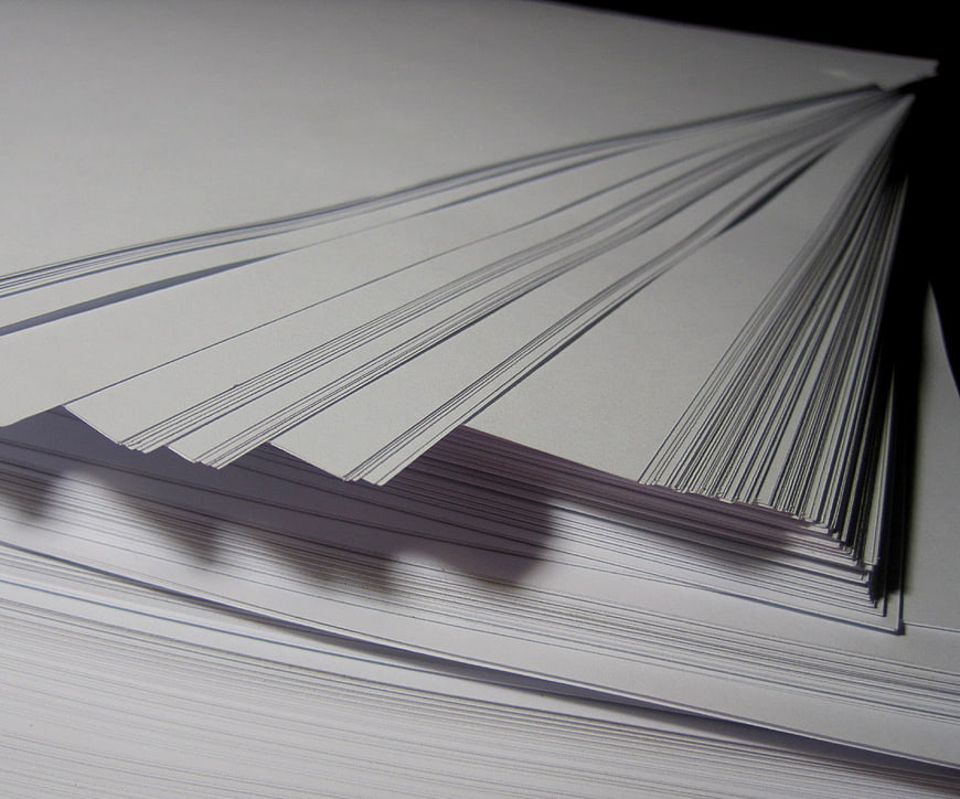 Stack of white paper sheets fanned out on a dark background