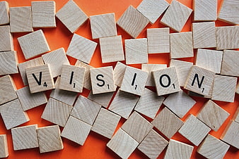 Wooden Scrabble Tiles Spelling Vision on Orange Background