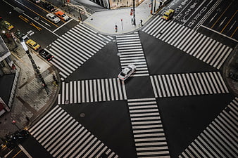 Aerial view of busy urban intersection with crosswalks and cars