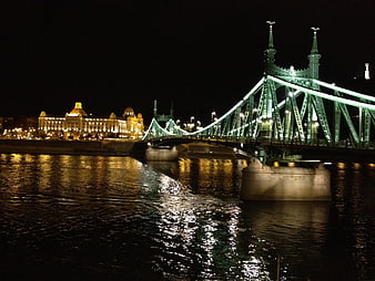 Night view of Liberty Bridge in Budapest with river reflections