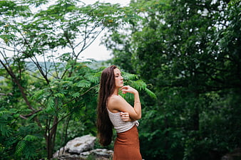 Young Woman with Long Hair in Lush Green Forest