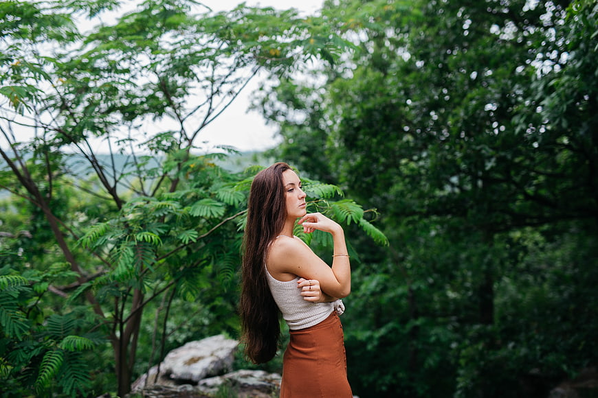 Young Woman with Long Hair in Lush Green Forest