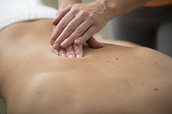 Close-up of hands performing a therapeutic back massage on a client