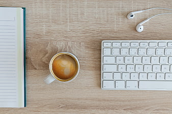 Top View of Minimalist Workspace with Coffee, Keyboard, and Notebook