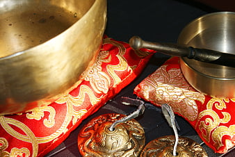 Golden Singing Bowls on Red Silk Cushions for Meditation