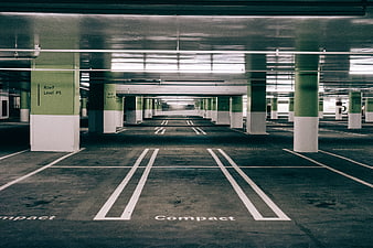 Empty underground parking garage with green and white pillars