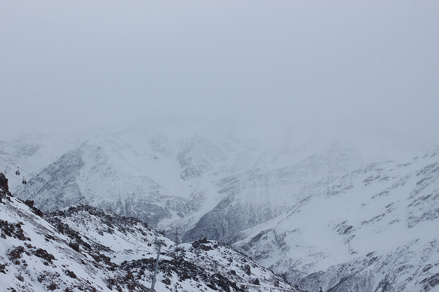 Snowy Mountain Landscape with Cable Car in Fog